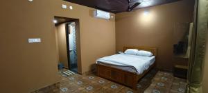 a small bedroom with a bed and a shower at Agastya Beach House in Ullāl