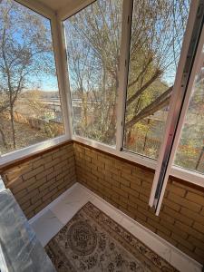 an empty room with two windows and a rug at Two-room apartment in Astana