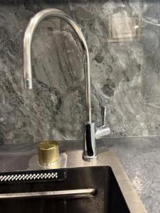 a kitchen sink with a faucet and a yellow container at Two-room apartment in Astana +21 photos