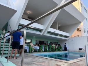 a group of people standing around a swimming pool at CASAMAR Olinda in Olinda