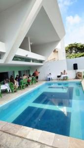 a large swimming pool with people sitting in chairs around it at CASAMAR Olinda in Olinda