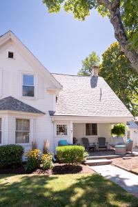 a white house with a patio and a yard at sisu, a boutique motel in Plymouth