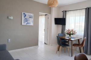 a living room with a table and chairs at Secret Garden Hotel in Maleme