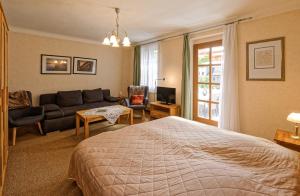 a bedroom with a bed and a living room with a couch at Pension Maria am Schlosspark in Gotha