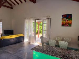 a kitchen and dining room with a table and chairs at Flamboyant in Sainte-Anne