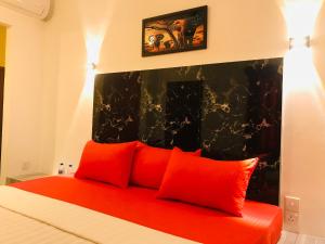 a bedroom with a bed with red pillows at Hasi Villa in Ahungalla