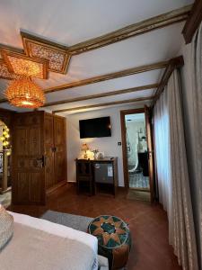 a bedroom with a bed and a television on the wall at Riad abi khancha in Chefchaouen