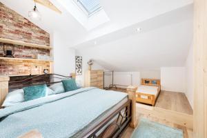 a bedroom with a bed and a brick wall at Apartmány Andrea s wellness in Zdíkov