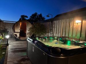 a hot tub with green lights in a backyard at B&B Groene oase in Bantega