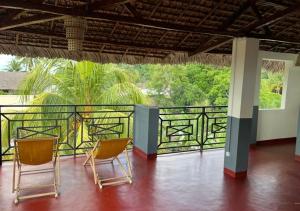 two chairs on a balcony with a view of a fence at Villa Magic in Nosy Be +25 photos