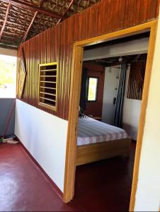 a bedroom with a bed with a wooden wall at Villa Magic in Nosy Be