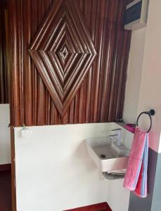 a bathroom with a sink and a wooden wall at Villa Magic in Nosy Be