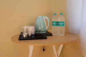 a table with a tea kettle and two bottles of water at Monkey River Resort Madla in Rājgarh