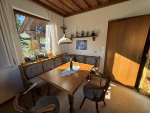a dining room with a wooden table and chairs at Ferienhaus Sonnhügel - Stissen in Faak am See