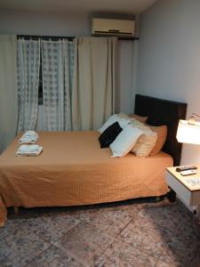 a bedroom with a bed with pillows on it at Palmeras II in Vicente López