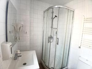 a white bathroom with a shower and a sink at Habitaciones El Escorial in Majadahonda