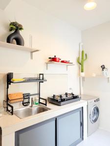 a kitchen with a sink and a washing machine at The Tuscan Townhouse in Tarlac
