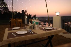 a table with plates and water bottles on top of it at Monkey River Resort Madla in Rājgarh