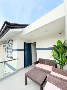 a patio with a bench and a blue door at The Tuscan Townhouse in Tarlac