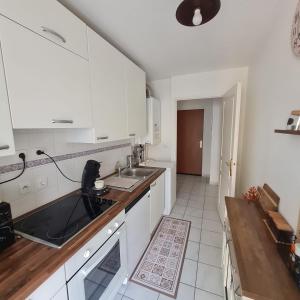 a kitchen with white cabinets and a sink at T3 spacieux hyper-centre - Familles & Pros - Genève à 5 min in Saint-Julien-en-Genevois +7 photos