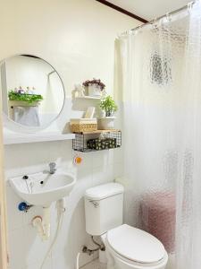 a bathroom with a toilet and a sink and a mirror at Casita del Mabini - Homestay in Mabini +97 photos