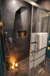 a shower with a glass door with candles in a bathroom at B&b GIOIA in Massa Lombarda