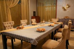 a dining room table with chairs and a table cloth at Hotel Arai Plaza in Taraz