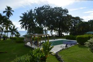 a pool with a gazebo next to the ocean at Hooked on Panama Lodge in Limones