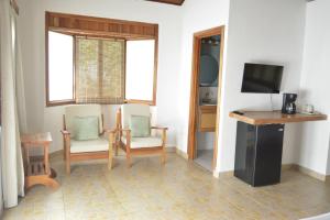 a living room with two chairs and a table and a television at Hooked on Panama Lodge in Limones