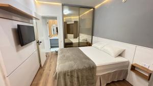 a small bedroom with a bed and a bathroom at Flat Premium -Acesso a pé ao shopping Center vale - Edifício Summit (Ar condicionado) in São José dos Campos