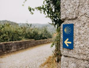 a blue sign on a wall next to a road at Minho AL in Paredes de Coura