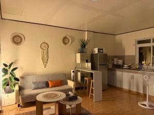 a living room with a couch and a kitchen at Casita del Mabini - Homestay in Mabini