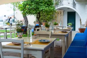 a group of tables and chairs with plants on them at Donna Clara in Agropoli +11 photos