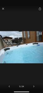 a picture of a tub with chairs and a table at Lazy Days Lodge in Malton