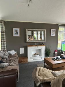 a living room with a couch and a table at Lazy Days Lodge in Malton
