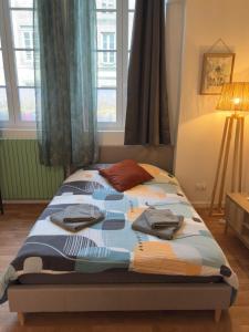 a bedroom with a bed with clothes on it at Studio Voyage - Proche centre ville in Mayenne