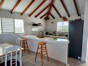 a kitchen with a counter and some stools at Flamboyant in Sainte-Anne