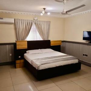 a bedroom with a bed and a television in a room at Elista Home in Tema +22 photos