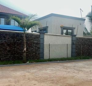a house with a palm tree in front of a wall at Elista Home in Tema