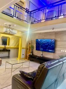 a living room with a couch and a tv on a wall at Elista Home in Tema