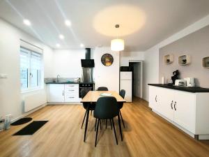 a kitchen and dining room with a table and chairs at maison cosy proche du port et plage in Grand-Fort-Philippe