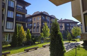 a group of buildings with benches in a park at Apartment Danik City Garden in Bansko