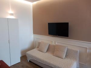 a living room with a couch with a tv on the wall at il glicine in Chieti