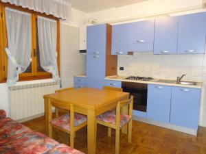 a kitchen with blue cabinets and a wooden table at Eraclea Mare in Eraclea Mare