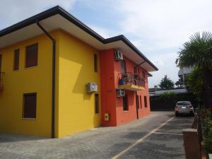 un edificio giallo e arancione con parcheggio di Eraclea Mare a Eraclea Mare