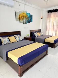 two beds in a room with two beds sidx sidx sidx at NO 10 Kandy by Kepler & Earth in Kandy