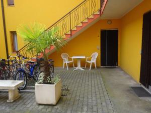 una camera gialla con tavolo, sedie e biciclette di Eraclea Mare a Eraclea Mare