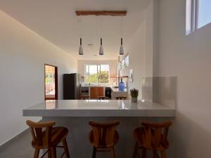 a kitchen with a large island with wooden bar stools at Almar in Olón