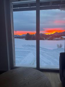 a bedroom window with a view of a snow covered field at Moderne Ferienwohnung nahe Salzburg & Eugendorf in Eugendorf