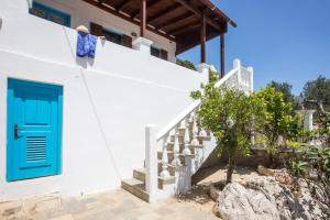 a blue door on a white house with stairs at Isminis Villa in Halki